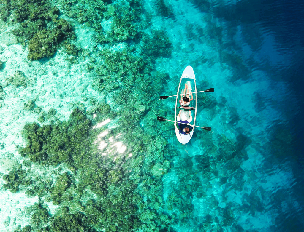 Aerial view of a kayak over the crystal-clear waters of the Maldives.