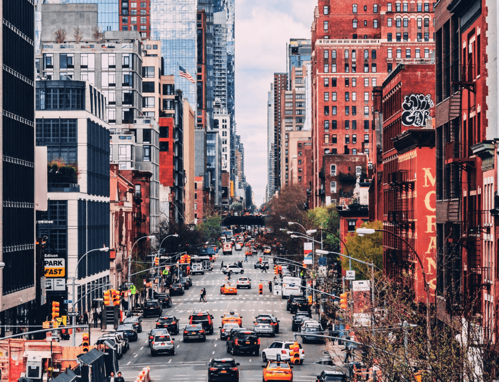 Lively streets of New York City with yellow cabs and diverse architecture, typical of the USA.