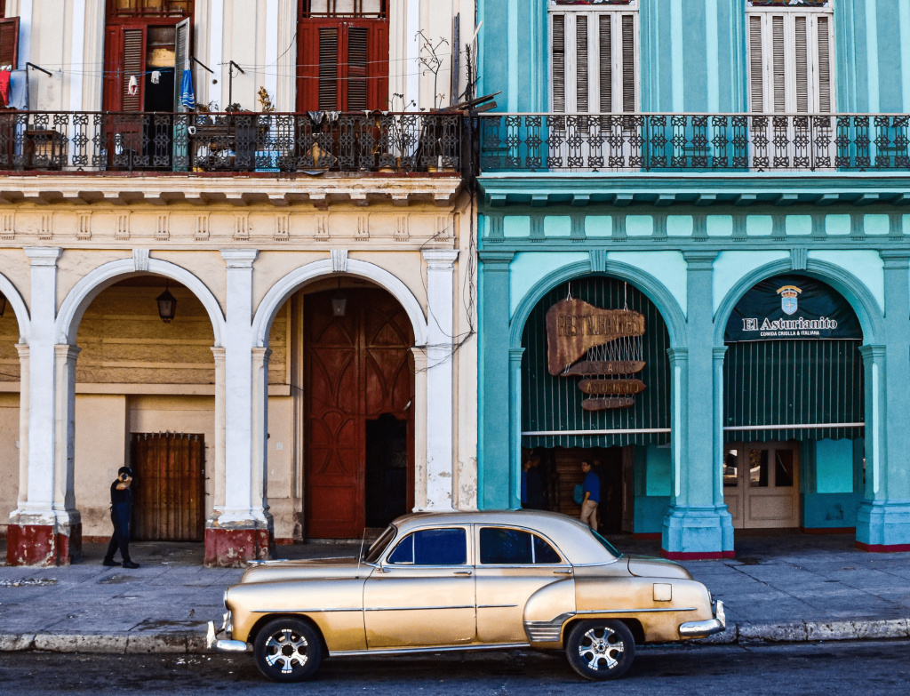 A classic car in front of colorful buildings in Havana, Cuba, reflecting the timeless culture.