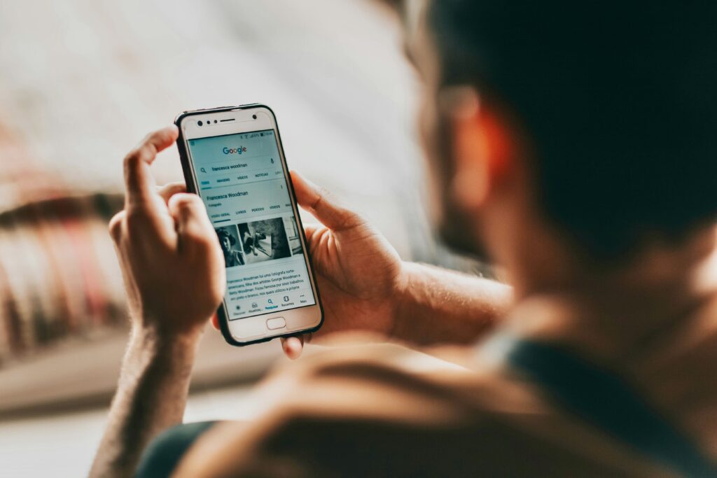 Person verwendet Google auf dem Smartphone, verdeutlicht die Dominanz mobiler Suchanfragen.