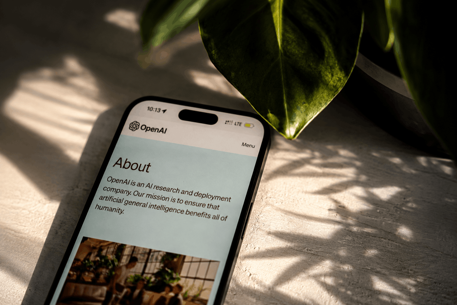 Smartphone displaying the OpenAI website, representing AI tools for modern content creation and social media marketing.